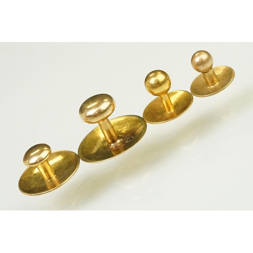 135 - Four gold collar / dress studs of plain form. Three marked 15ct, one with rubbed mark. Largest measu... 