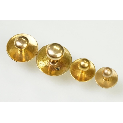 135 - Four gold collar / dress studs of plain form. Three marked 15ct, one with rubbed mark. Largest measu... 