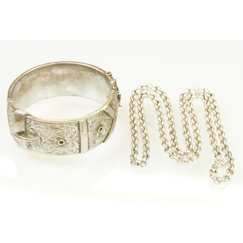 143 - Silver hallmarked buckle bangle handing applied and engraved details with a hinged mechanism. Hallma... 