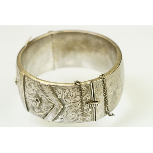 143 - Silver hallmarked buckle bangle handing applied and engraved details with a hinged mechanism. Hallma... 