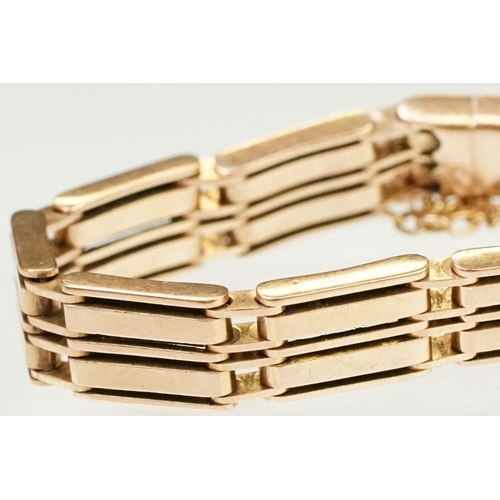 149 - 10ct rose gold gate link bracelet having a tongue in groove clasp with safety chain. Clasp marked 10... 