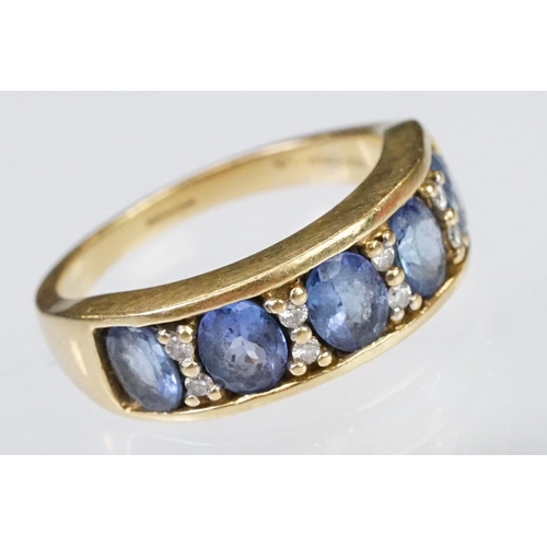 158 - 18ct gold tanzanite and diamond ring. The ring being set with five oval cut tanzanite's with round c... 