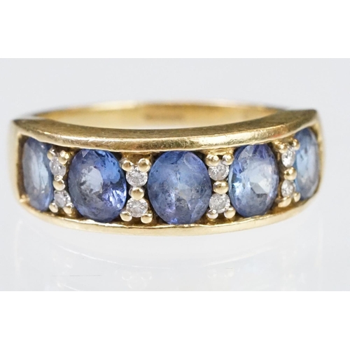 158 - 18ct gold tanzanite and diamond ring. The ring being set with five oval cut tanzanite's with round c... 