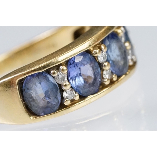 158 - 18ct gold tanzanite and diamond ring. The ring being set with five oval cut tanzanite's with round c... 