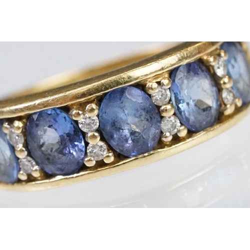 158 - 18ct gold tanzanite and diamond ring. The ring being set with five oval cut tanzanite's with round c... 