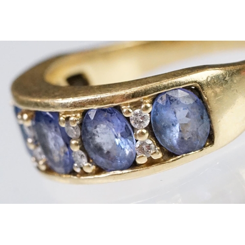 158 - 18ct gold tanzanite and diamond ring. The ring being set with five oval cut tanzanite's with round c... 