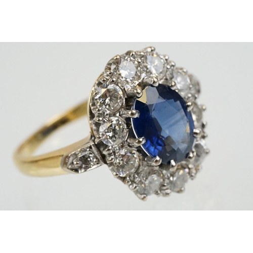 16 - 18ct gold, sapphire and diamond cluster ring being set with an oval mixed but clue sapphire with a h... 