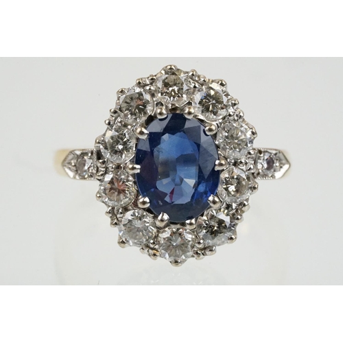 16 - 18ct gold, sapphire and diamond cluster ring being set with an oval mixed but clue sapphire with a h... 