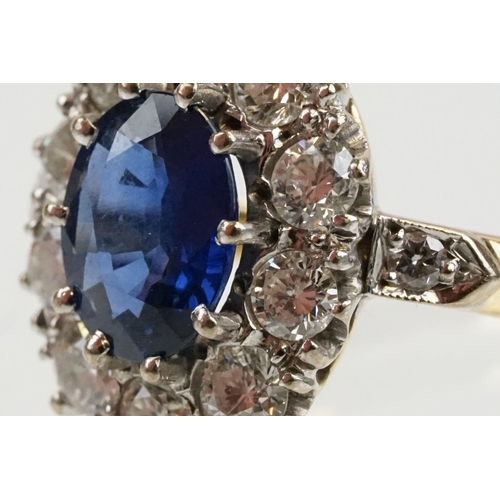 16 - 18ct gold, sapphire and diamond cluster ring being set with an oval mixed but clue sapphire with a h... 