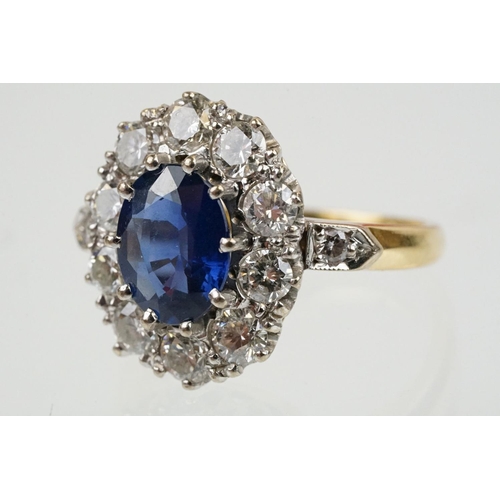 16 - 18ct gold, sapphire and diamond cluster ring being set with an oval mixed but clue sapphire with a h... 