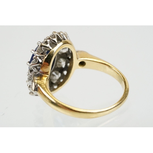 16 - 18ct gold, sapphire and diamond cluster ring being set with an oval mixed but clue sapphire with a h... 