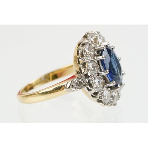 16 - 18ct gold, sapphire and diamond cluster ring being set with an oval mixed but clue sapphire with a h... 