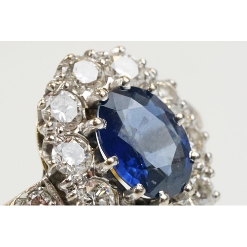 16 - 18ct gold, sapphire and diamond cluster ring being set with an oval mixed but clue sapphire with a h... 