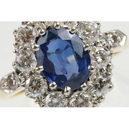 16 - 18ct gold, sapphire and diamond cluster ring being set with an oval mixed but clue sapphire with a h... 