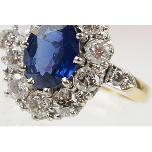 16 - 18ct gold, sapphire and diamond cluster ring being set with an oval mixed but clue sapphire with a h... 