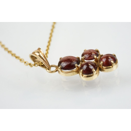 176 - 15ct gold and garnet cabochon pendant set with four cabochons with bale to top, mounted to a fine li... 