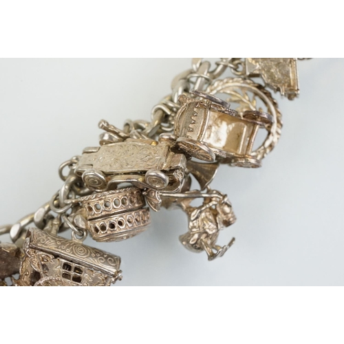 196 - Vintage silver charm bracelet having a curb link chain with box clasp adorned with approximately 21 ... 