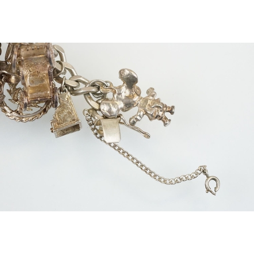 196 - Vintage silver charm bracelet having a curb link chain with box clasp adorned with approximately 21 ... 