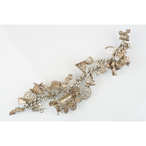 196 - Vintage silver charm bracelet having a curb link chain with box clasp adorned with approximately 21 ... 