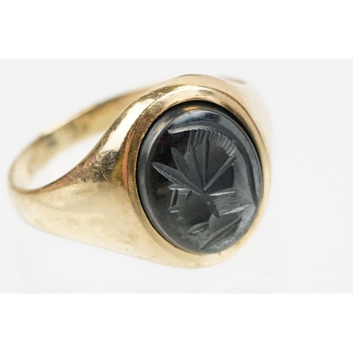 209 - 9ct gold hallmarked hematite signet ring being set with an oval panel to the head engraved with a ro... 