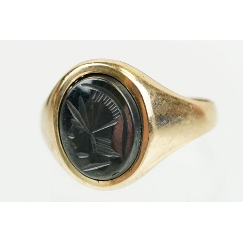 209 - 9ct gold hallmarked hematite signet ring being set with an oval panel to the head engraved with a ro... 