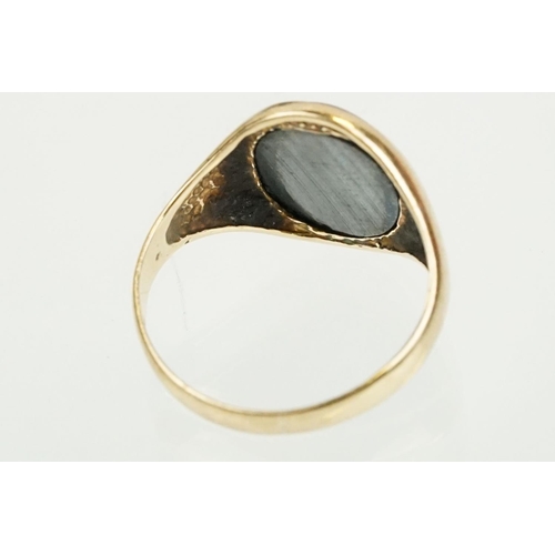 209 - 9ct gold hallmarked hematite signet ring being set with an oval panel to the head engraved with a ro... 