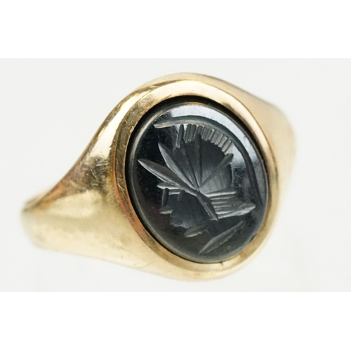 209 - 9ct gold hallmarked hematite signet ring being set with an oval panel to the head engraved with a ro... 