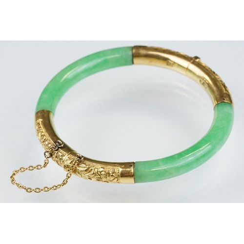 25 - Chinese jade and gold hinged bangle bracelet. The bracelet of round form with gold hinge section and... 