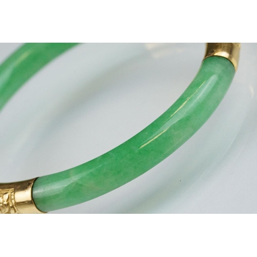 25 - Chinese jade and gold hinged bangle bracelet. The bracelet of round form with gold hinge section and... 