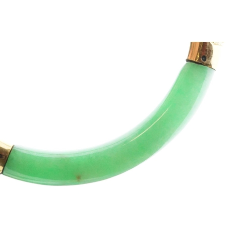 25 - Chinese jade and gold hinged bangle bracelet. The bracelet of round form with gold hinge section and... 