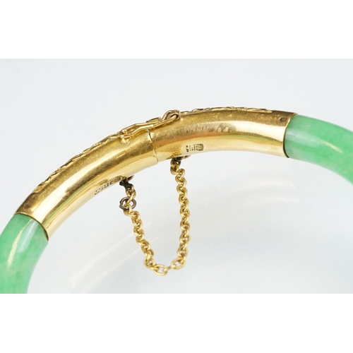 25 - Chinese jade and gold hinged bangle bracelet. The bracelet of round form with gold hinge section and... 