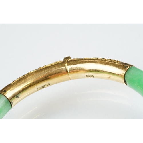 25 - Chinese jade and gold hinged bangle bracelet. The bracelet of round form with gold hinge section and... 