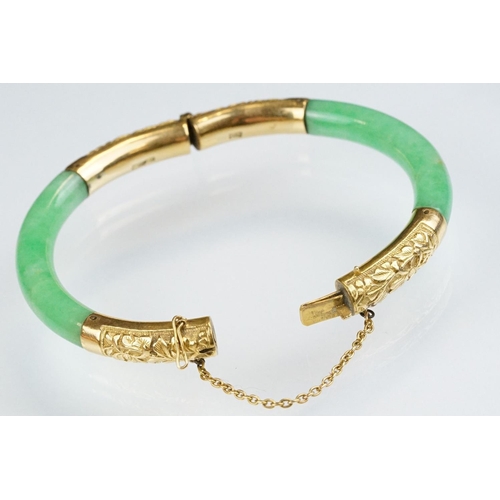 25 - Chinese jade and gold hinged bangle bracelet. The bracelet of round form with gold hinge section and... 