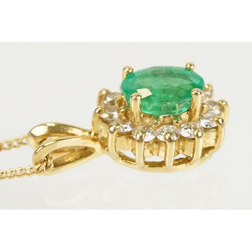 262 - Emerald and diamond halo pendant set to 9ct gold trace chain. The pendant set with an oval cut emera... 