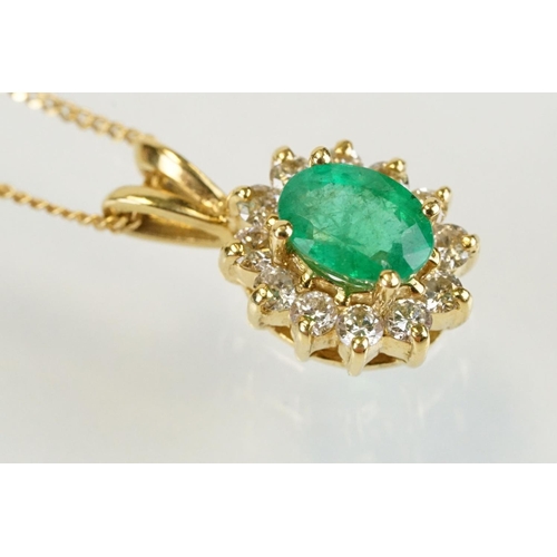 262 - Emerald and diamond halo pendant set to 9ct gold trace chain. The pendant set with an oval cut emera... 