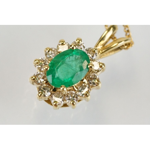 262 - Emerald and diamond halo pendant set to 9ct gold trace chain. The pendant set with an oval cut emera... 