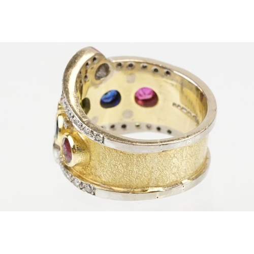 264 - 18ct gold, ruby, sapphire and diamond ring. The ring bezel set with a green round cut sapphire to ce... 