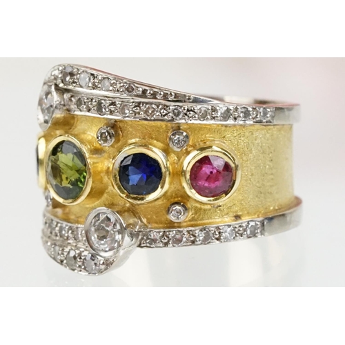 264 - 18ct gold, ruby, sapphire and diamond ring. The ring bezel set with a green round cut sapphire to ce... 