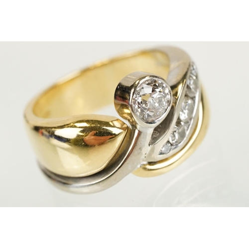 266 - 18ct gold and diamond cross over style ring being bezel set with a round cut diamond to the centre w... 