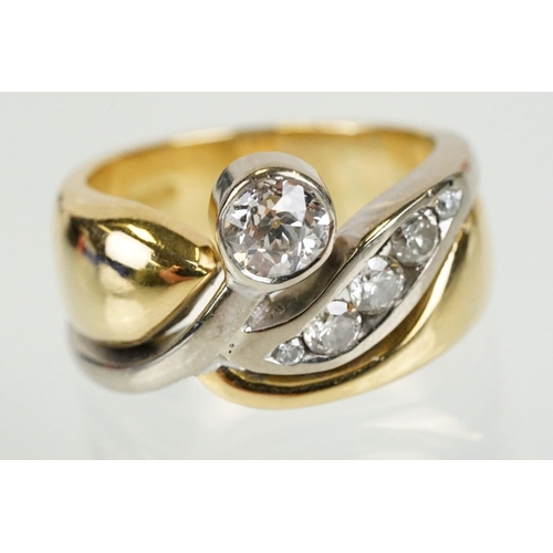 266 - 18ct gold and diamond cross over style ring being bezel set with a round cut diamond to the centre w... 