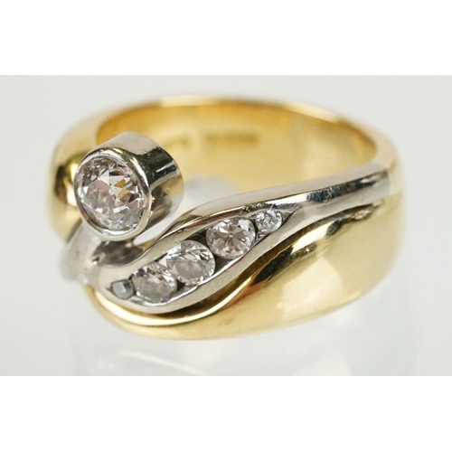 266 - 18ct gold and diamond cross over style ring being bezel set with a round cut diamond to the centre w... 