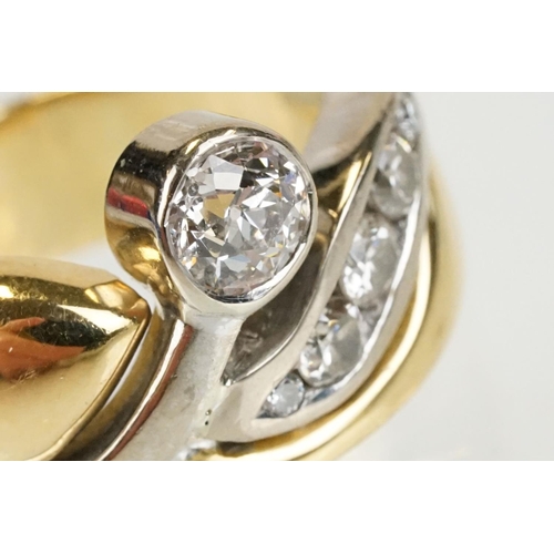 266 - 18ct gold and diamond cross over style ring being bezel set with a round cut diamond to the centre w... 