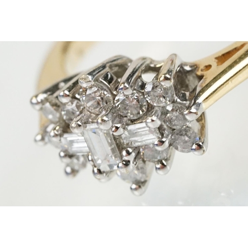 278 - 9ct gold and diamond cluster ring being set with three baguette cut diamonds surrounded by twelve ro... 