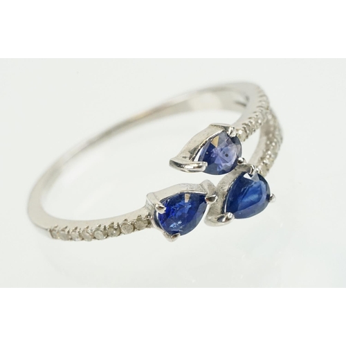 282 - Silver sapphire and diamond ring being set with three pear cut blue sapphires, with diamond accent s... 