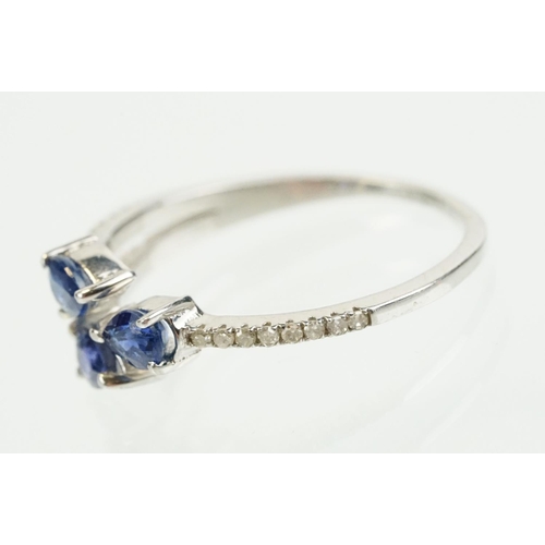 282 - Silver sapphire and diamond ring being set with three pear cut blue sapphires, with diamond accent s... 