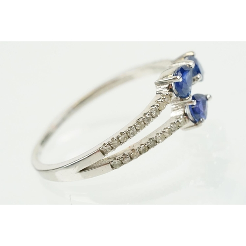 282 - Silver sapphire and diamond ring being set with three pear cut blue sapphires, with diamond accent s... 