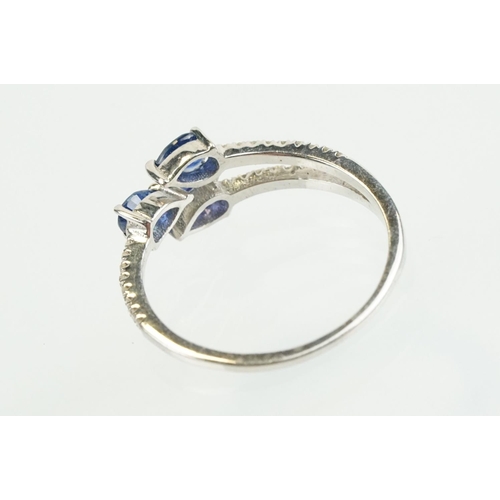 282 - Silver sapphire and diamond ring being set with three pear cut blue sapphires, with diamond accent s... 