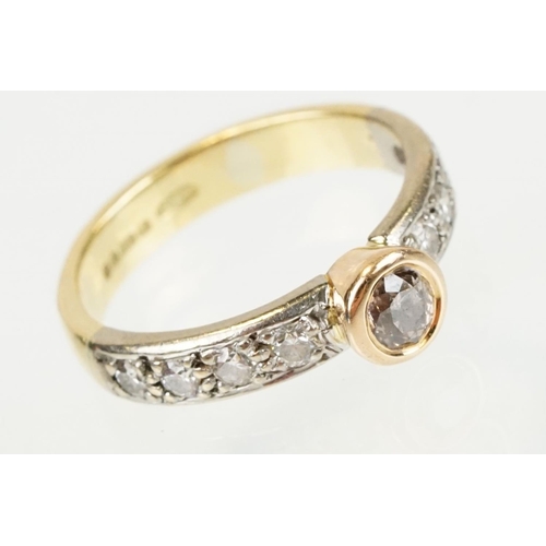 288 - 18ct gold tri tone diamond ring having a central round cut diamond set in a bezel setting with diamo... 