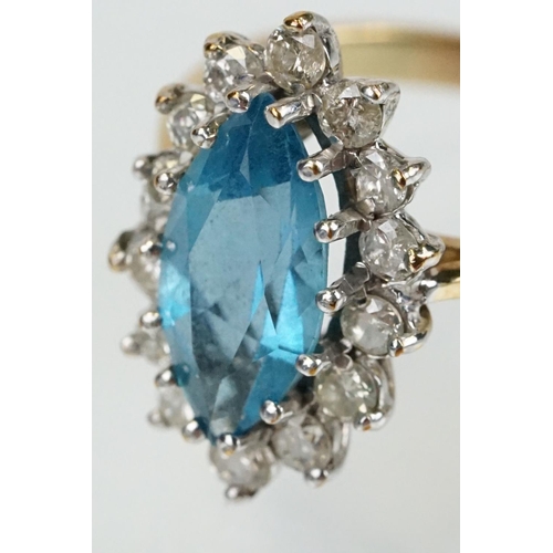 290 - 9ct gold, topaz and diamond cluster ring. The ring being set with a marquise cut blue topaz with a h... 