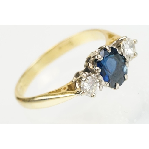 292 - 18ct gold sapphire and diamond three stone ring. The ring being set with an oval cut sapphire flanke... 